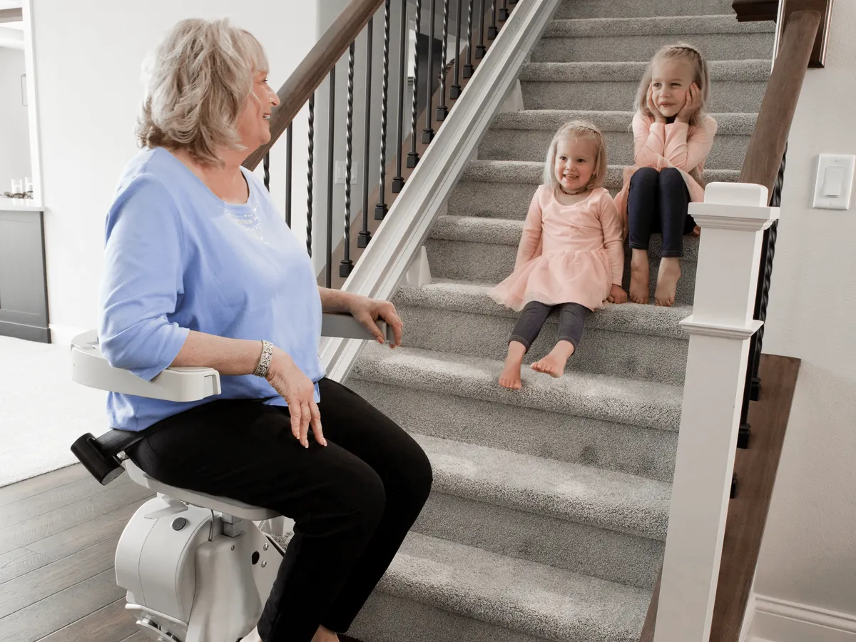Bruno stairlift on a straight staircase, a grandmother talking with her grandchildren